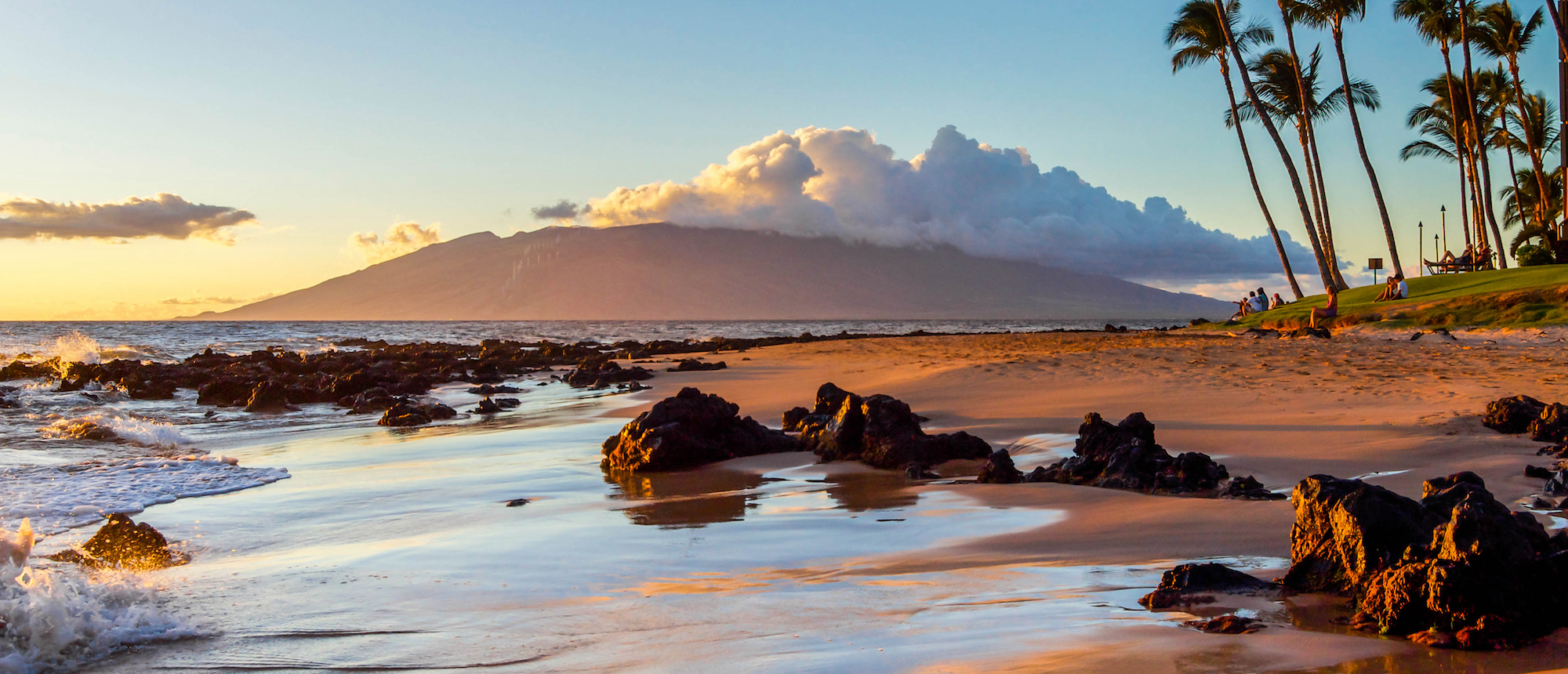 The glow of sunset is reflected on a Maui beach.